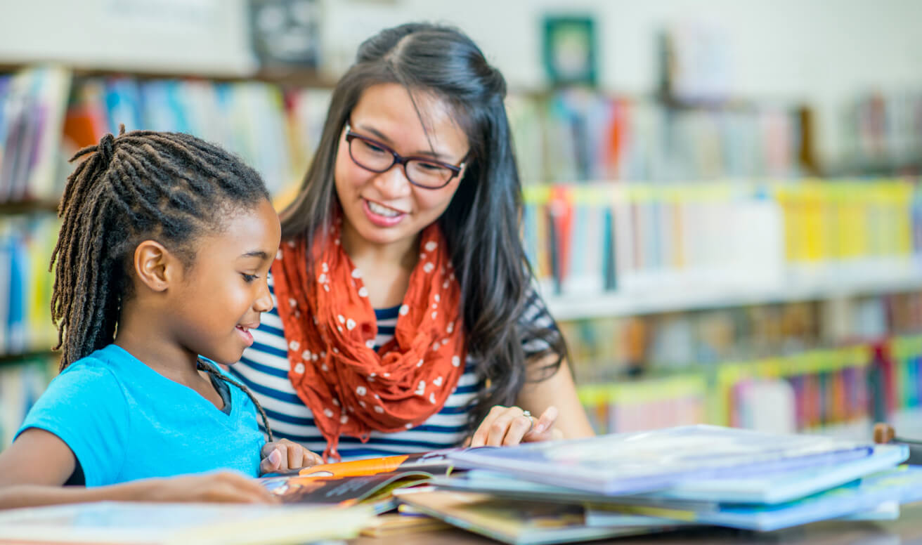 BCBA clinician reading to an ABA girl